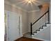 Inviting foyer featuring a staircase with black banister, hardwood floors, and a view to the exterior at 1052 Secret Ne Trl, Sugar Hill, GA 30518