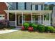 Inviting front porch adorned with hanging plants and charming landscaping at 1052 Secret Ne Trl, Sugar Hill, GA 30518
