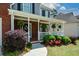 Close-up of the front porch featuring hanging plants and a welcoming wreath on the front door at 1052 Secret Ne Trl, Sugar Hill, GA 30518