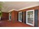 Cozy covered front porch with classic brick detailing, decorative sconces, and a cheerful welcome mat at 1052 Secret Ne Trl, Sugar Hill, GA 30518