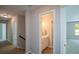 Hallway featuring neutral walls and carpet, with doorways leading to a bathroom and bedroom with natural light streaming through the window at 1052 Secret Ne Trl, Sugar Hill, GA 30518
