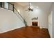 Bright living room with a fireplace, hardwood floors, and adjacent staircase at 1052 Secret Ne Trl, Sugar Hill, GA 30518