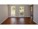 Inviting living room with gleaming hardwood floors and natural light from the large windows at 1052 Secret Ne Trl, Sugar Hill, GA 30518