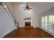 Bright living room featuring fireplace, hardwood floors, staircase, and natural light from large windows at 1052 Secret Ne Trl, Sugar Hill, GA 30518