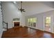 Spacious living room with vaulted ceiling, brick fireplace, and a door leading to porch at 1052 Secret Ne Trl, Sugar Hill, GA 30518