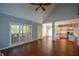 Open-concept living room showcasing hardwood floors, large windows, and adjacent kitchen area at 1052 Secret Ne Trl, Sugar Hill, GA 30518