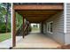 Covered patio with wooden stairs and mature trees offers a versatile outdoor space for relaxation and entertaining at 1052 Secret Ne Trl, Sugar Hill, GA 30518