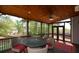 Inviting screened porch features wood ceiling, ceiling fan, stylish outdoor furniture and views of the landscaped backyard at 1052 Secret Ne Trl, Sugar Hill, GA 30518