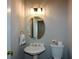 Elegant powder room features an oval mirror, stylish lighting, and a classic pedestal sink at 1052 Secret Ne Trl, Sugar Hill, GA 30518