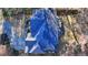 Aerial view of a home with a blue roof, lush backyard, and a long driveway at 1081 Talon Trce, Lawrenceville, GA 30043