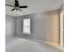 Neutral-toned bedroom featuring a ceiling fan, window, and wall outlets at 1081 Talon Trce, Lawrenceville, GA 30043