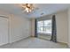 Bright bedroom with a ceiling fan, large window, and closet space at 1081 Talon Trce, Lawrenceville, GA 30043