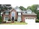 Well maintained brick home with an attached garage and arched window framed by landscaped yard at 1081 Talon Trce, Lawrenceville, GA 30043