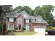 Attractive brick home with attached garage, complemented by an arched window and a landscaped front yard at 1081 Talon Trce, Lawrenceville, GA 30043