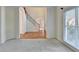 Open living area with neutral carpet, large windows and access to staircase at 1081 Talon Trce, Lawrenceville, GA 30043