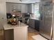 Bright kitchen with granite island, stainless steel appliances, updated cabinets, and hardwood floors at 1425 Parkmont Dr, Roswell, GA 30076