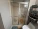 Shower room with a glass door, white tiles, and convenient shelf storage at 1425 Parkmont Dr, Roswell, GA 30076
