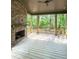 Covered back porch with brick fireplace and wood plank flooring overlooks a wooded area at 2461 Fernleaf Nw Ct, Atlanta, GA 30318