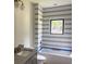 Modern bathroom with striped tile, bathtub with black trim window, and a gray vanity at 2461 Fernleaf Nw Ct, Atlanta, GA 30318