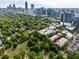 Aerial view of buildings within a tree-filled community, set against a stunning city skyline at 273 12Th Ne St # 313, Atlanta, GA 30309