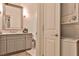 Bathroom with stackable washer and dryer beside gray vanity and framed mirror at 273 12Th Ne St # 313, Atlanta, GA 30309