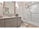 Bright bathroom boasts marble floors and shower, gray vanity and framed mirror at 273 12Th Ne St # 313, Atlanta, GA 30309