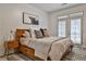 Cozy bedroom featuring a wooden bed frame, stylish rug and natural light from the french doors at 273 12Th Ne St # 313, Atlanta, GA 30309