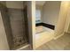 Bathroom showcasing a separate tub and shower with stone floors and tiled surround at 3472 Riverview Chase Way, Ellenwood, GA 30294