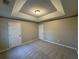 Spacious carpeted bedroom featuring a tray ceiling and two closets at 3472 Riverview Chase Way, Ellenwood, GA 30294