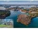 Stunning aerial view of lakefront property with dock and surrounding wooded areas at 6337 Ansel Ct, Buford, GA 30518