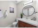 Bathroom featuring vanity with wood cabinets, white sink and toilet with decorative wall art at 706 Twin Brooks Se Ct, Marietta, GA 30067