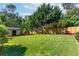 Large, fenced backyard featuring a well-maintained lawn, storage shed, and mature trees at 1081 Singleton Valley Cir, Norcross, GA 30093