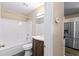 Compact bathroom featuring a vanity, tub, shower, and toilet next to the kitchen and stainless steel refrigerator at 1081 Singleton Valley Cir, Norcross, GA 30093