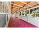 Spacious enclosed porch with red floors, offering views of the private backyard at 1081 Singleton Valley Cir, Norcross, GA 30093