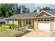 Charming single-story home with a well-maintained lawn, white picket fence, and attached garage on a sunny day at 1081 Singleton Valley Cir, Norcross, GA 30093