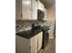 A kitchen with white cabinets, dark countertops, stainless steel appliances, and mosaic tile backsplash at 1081 Singleton Valley Cir, Norcross, GA 30093
