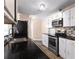 Modern kitchen featuring sleek black countertops, stainless steel appliances, white cabinets, and decorative backsplash at 1081 Singleton Valley Cir, Norcross, GA 30093