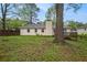 Rear exterior featuring a backyard with grassy lawn and mature shade trees at 1248 Reilly Ln, Clarkston, GA 30021