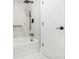 Bathroom featuring white marbled tile, matte black hardware, and shower with tub at 1248 Reilly Ln, Clarkston, GA 30021