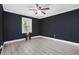 Stylish bedroom with dark walls, light floors, ceiling fan and bright window at 1248 Reilly Ln, Clarkston, GA 30021