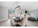 Open-concept dining area with modern light fixture, wood floors, and comfortable seating near the living room at 1248 Reilly Ln, Clarkston, GA 30021