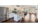A modern kitchen featuring stainless steel appliances, white cabinets, a kitchen island with barstool seating, and hardwood floors at 245 Fender Walk, Marietta, GA 30060