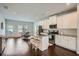 A modern kitchen featuring stainless steel appliances, white cabinets, a kitchen island with barstool seating, and hardwood floors at 245 Fender Walk, Marietta, GA 30060