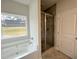 A tub next to the window and a glassed-in shower enhance this bathroom at 80 Hawthorn Ln, Covington, GA 30014