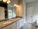 Bathroom featuring double sink vanity with granite countertop, tile floor, and custom mirror at 80 Hawthorn Ln, Covington, GA 30014