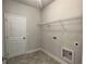 Interior laundry room features tile floors, white walls, shelving, and access door at 80 Hawthorn Ln, Covington, GA 30014