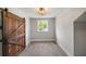 Empty bedroom with modern barn door, carpet, and large window at 1535 Deerwood Dr, Decatur, GA 30030