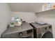 Compact laundry room features updated washer and dryer and added storage with wire shelving on a white wall at 1535 Deerwood Dr, Decatur, GA 30030