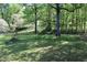 Landscaped backyard with mature trees and fire pit at 1646 Hurt Sw Rd, Marietta, GA 30008