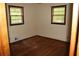 This bedroom features two windows and hardwood floors at 1646 Hurt Sw Rd, Marietta, GA 30008
